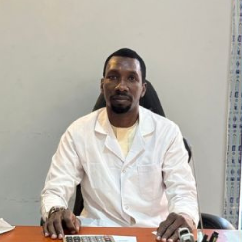 Mr. Ahmad Mahmoud, wearing a white coat and sitting at a desk with a keyboard in front of him